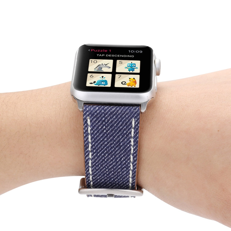 Blue woven watch band on wrist with metal buckle and tan leather underside, contrast stitching