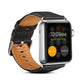 Black leather watch band with metal buckle and stitched holes, shown on watch face