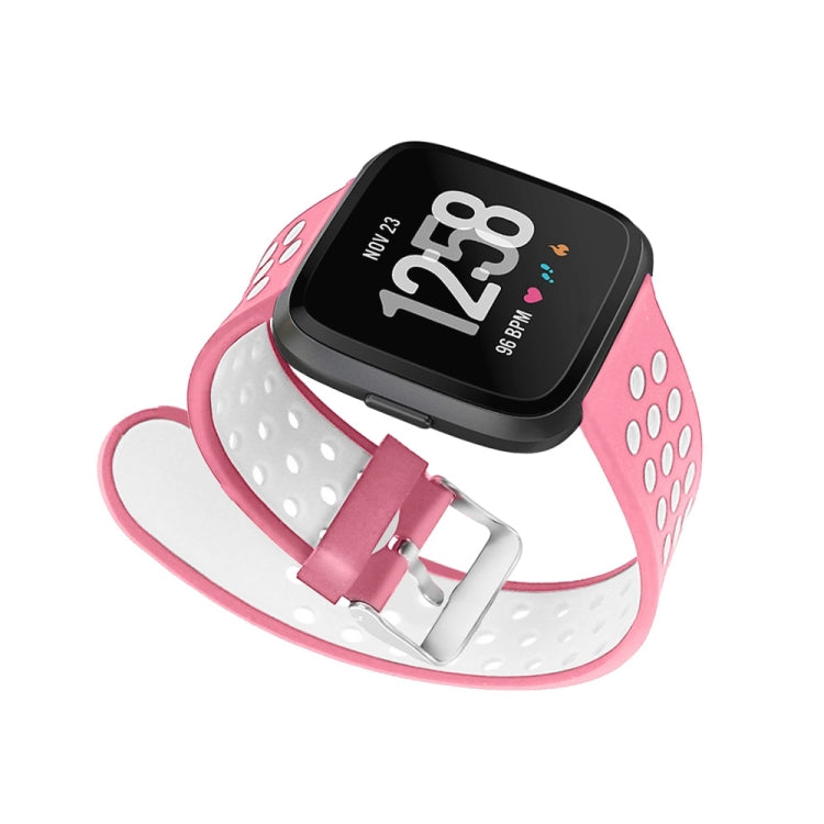 Pink silicone perforated watch band with metal clasp and white underside