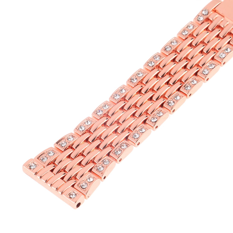 Rose gold metal watch band close-up with rhinestone-set links and patterned openings.
