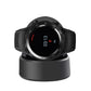 Black smartwatch resting on a round magnetic charging cradle base