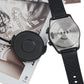 Black smartwatch on strap with charging puck and cable