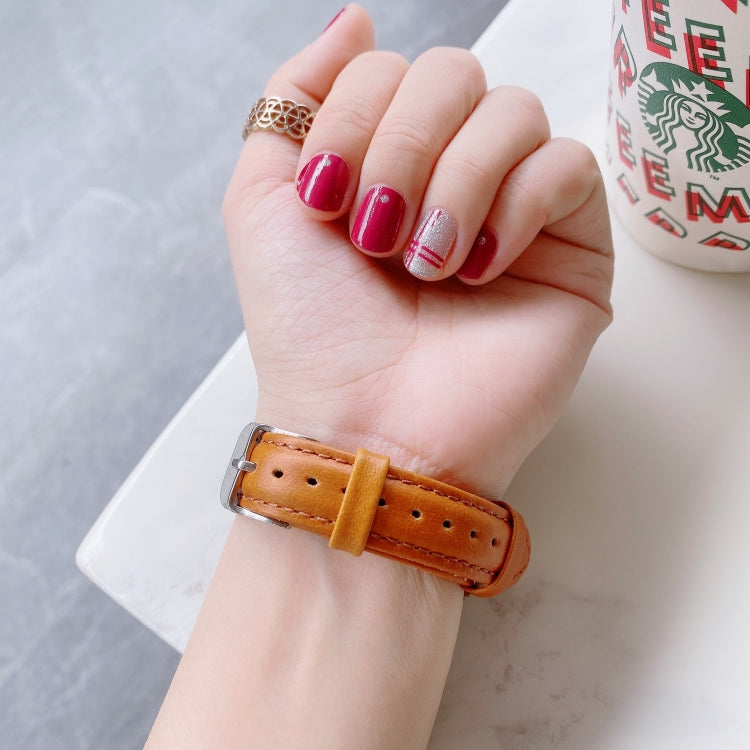 22mm leather watch band with silver buckle on wrist, double-sided strap in tan