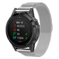 Silver milanese watch band with clasp on a round smartwatch