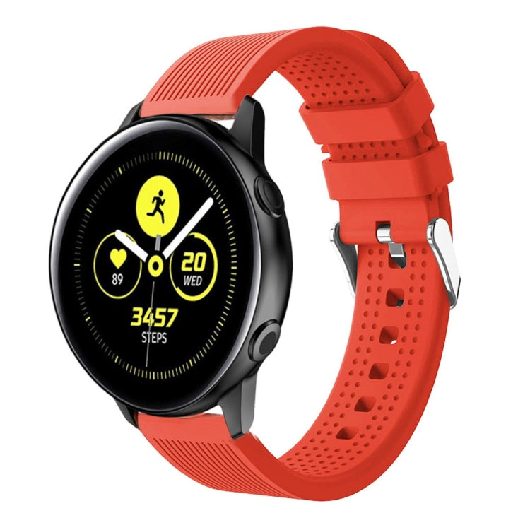 Red-orange silicone smartwatch band with perforated strap and metal buckle hardware