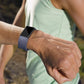 Blue diamond-pattern sport watch band worn on a wrist with adjustable strap holes.