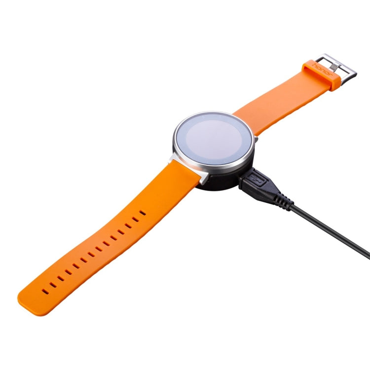 Orange wearable device with charging cable connected to the side port
