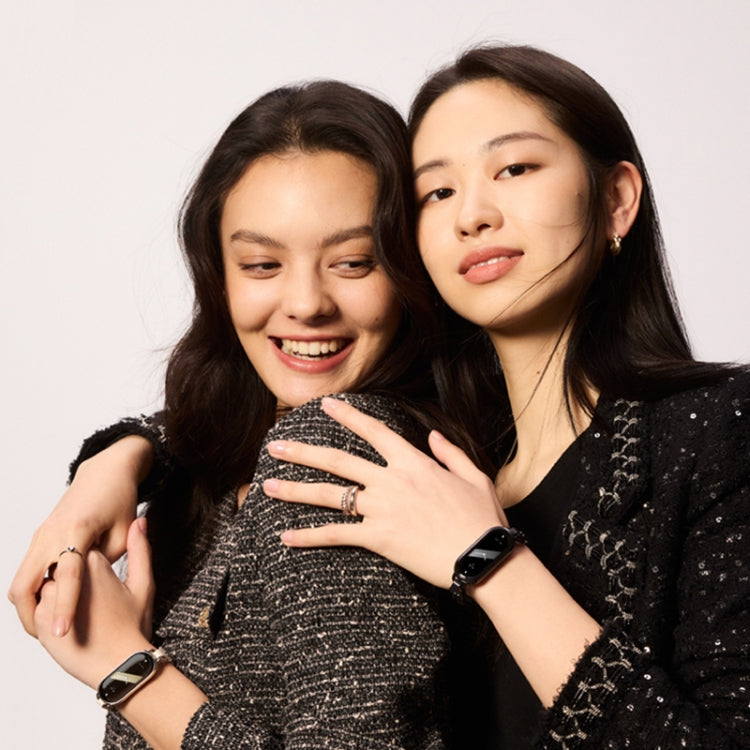 Two women wearing fitness smart watches with chain bracelets