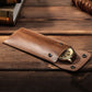 Leather watch protective case holding a watch with snap closure and metal button