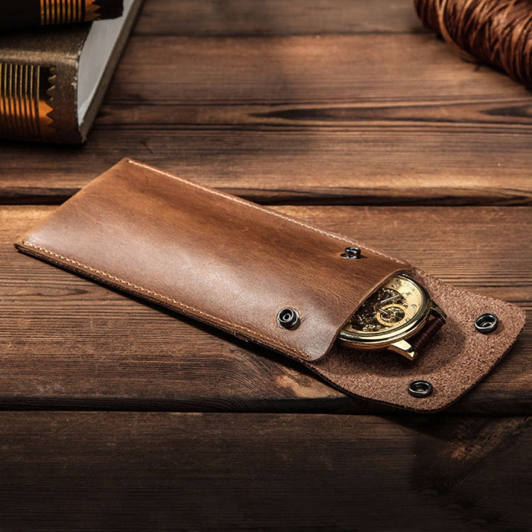 Leather watch protective case holding a watch with snap closure and metal button
