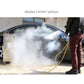 Steam water gun spraying mist, held by a worker with black grip and metal nozzle