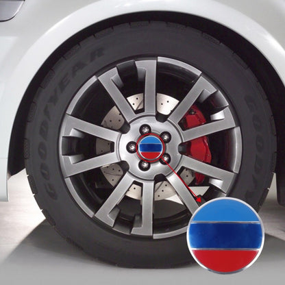 Metal wheel center badge with blue, white, and red flag design on car rim