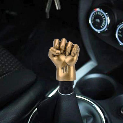 Gold aluminum fist-shaped gear shift knob with textured black grip ring