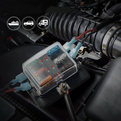 Black 6-way car fuse block with clear cover and colored blade fuses, mounted in wiring bay