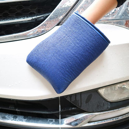 Blue car washer glove with thick cuff, held over a vehicle front for cleaning