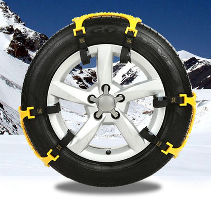 Yellow snow tire anti-skid chain on silver wheel rim, with black strap and metal links