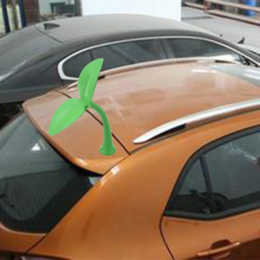 Green decorative rubber grass topper on car hood near windshield and wiper
