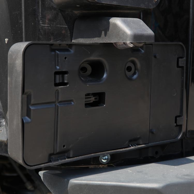 Close-up of black rear license plate bracket with mounting holes and wiring