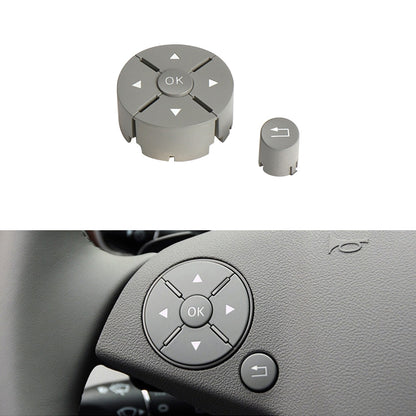 Grey steering wheel switch button panel with OK ring and arrow icons, left control