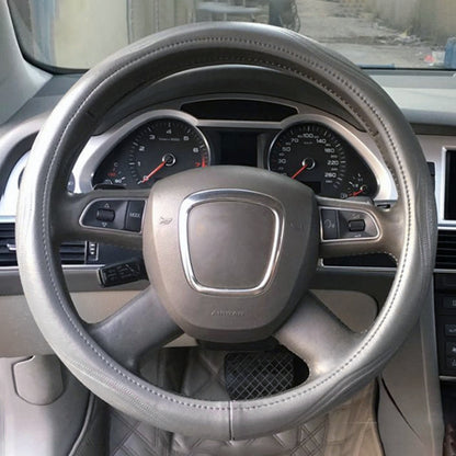 Grey leather steering wheel cover with perforated grip and contrast stitching