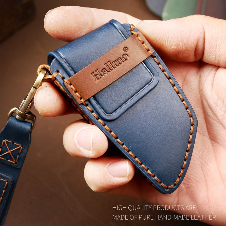 Blue leather key fob cover held in hand with stitched trim and metal ring