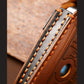 Close-up of stitched edge on blue leather key fob cover with emblem front
