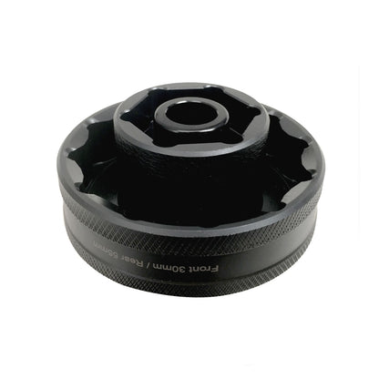 Black wheel nut socket tool with textured grip and central drive opening