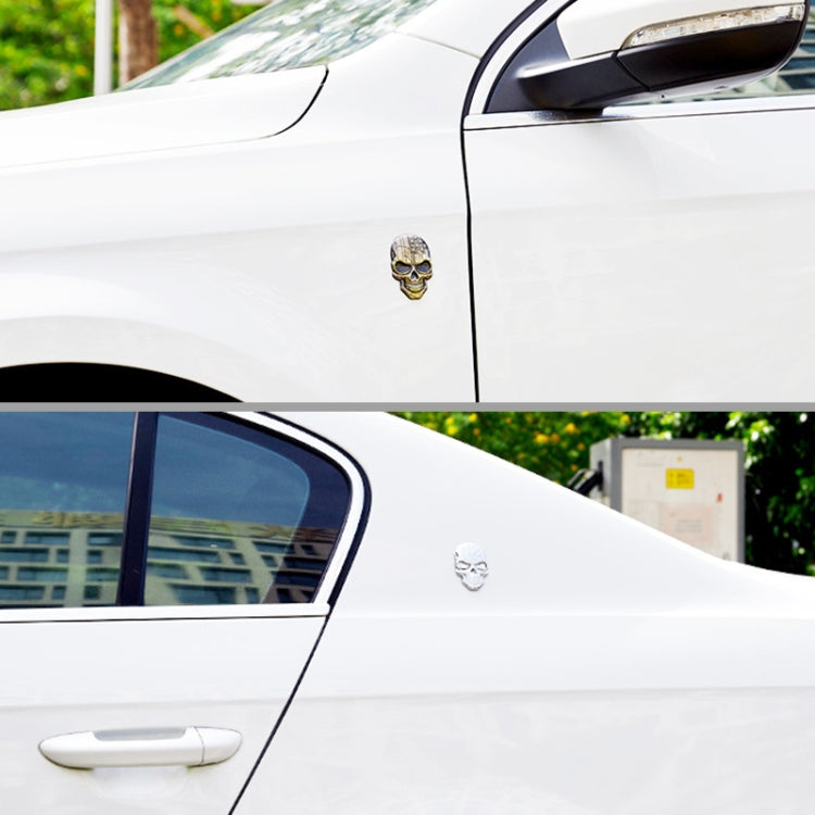 Bronze, white, and silver devil skull metal car stickers on a vehicle body