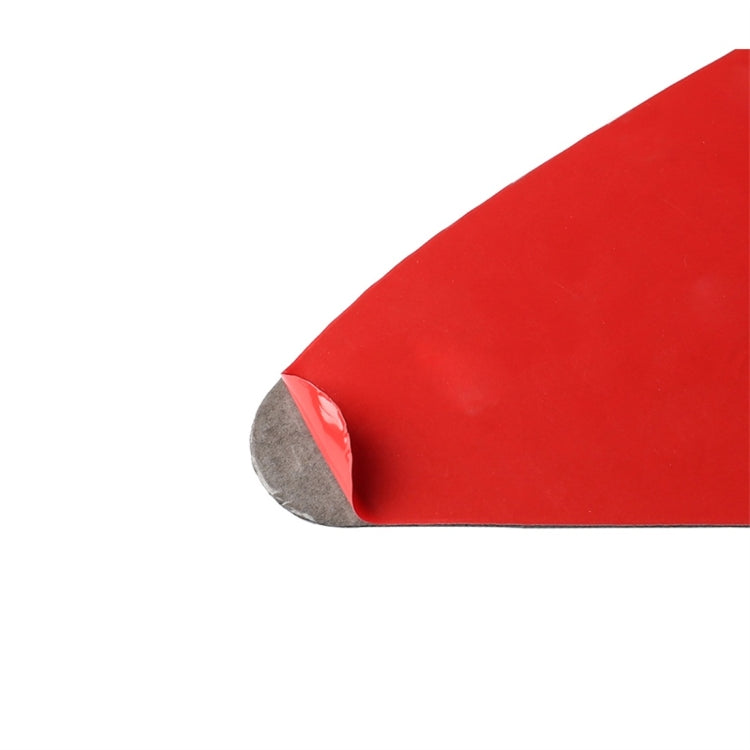 Wedge carbon fiber sticker with gray backing, applied edge on red vehicle surface