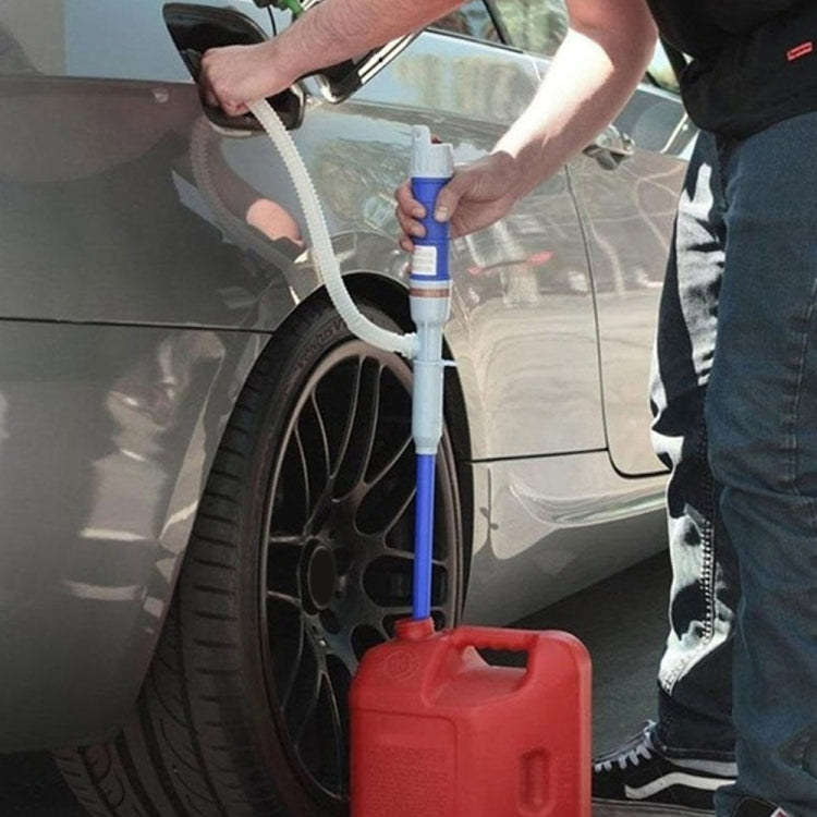 Car electric oil pump with white tube, blue handle, and red container during use