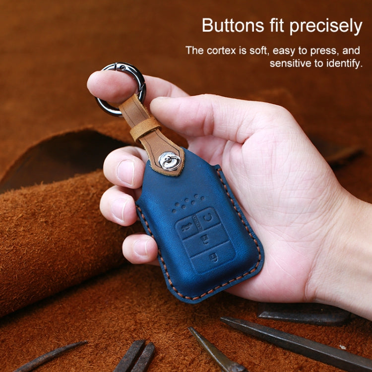 Blue leather key fob cover held in hand with embossed button panel and keyring