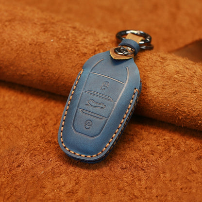 Blue cowhide leather key protective cover with embossed button icons and stitched edges.