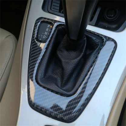 Carbon-fiber gear panel trim sticker around black shift boot, left-drive style.