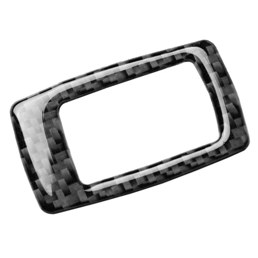 Carbon fiber-look trunk switch trim bezel with rectangular opening, angled view