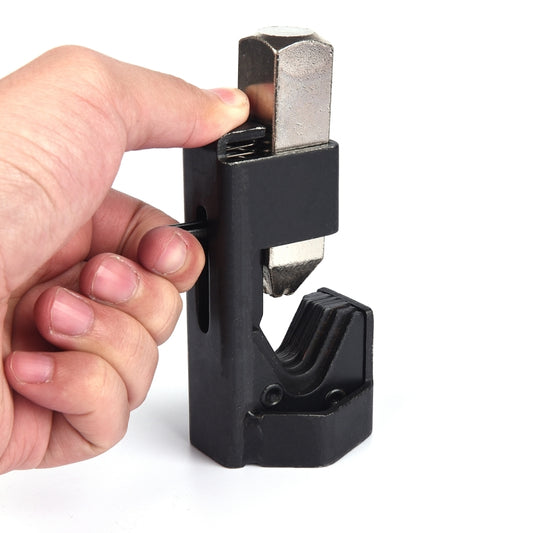 Hand holding hammer lug crimper tool on metal die for wire terminals