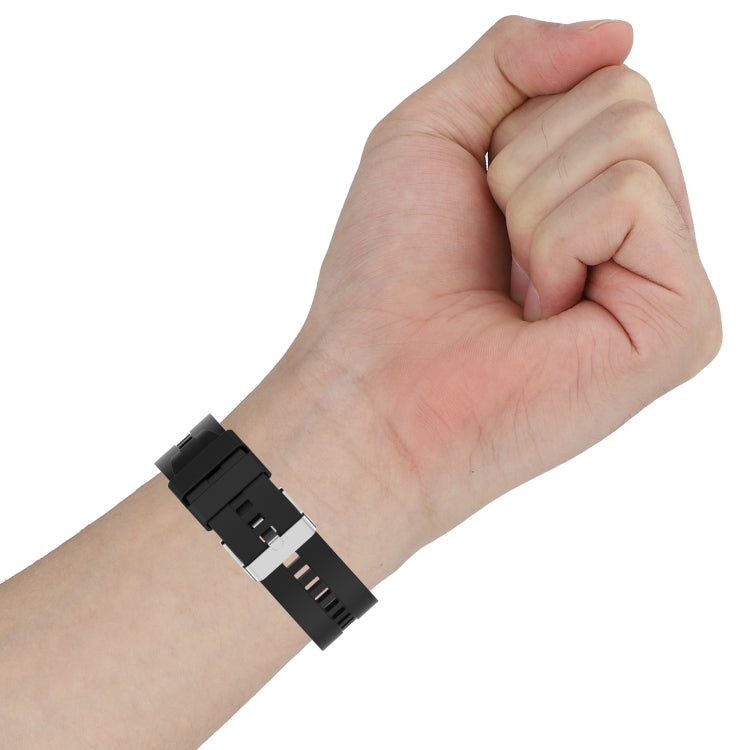 Black silicone watch strap close-up on wrist with metal buckle and pin holes