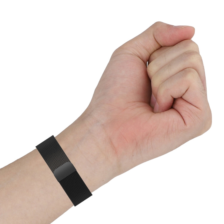 Black Milanese mesh watch strap on wrist with buckle clasp