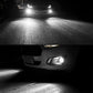Car fog lights glowing white, bright LED beam visible from front bumper housing