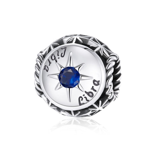Sterling silver zodiac ring with dark blue zircon center, starburst bezel, engraved constellation symbols