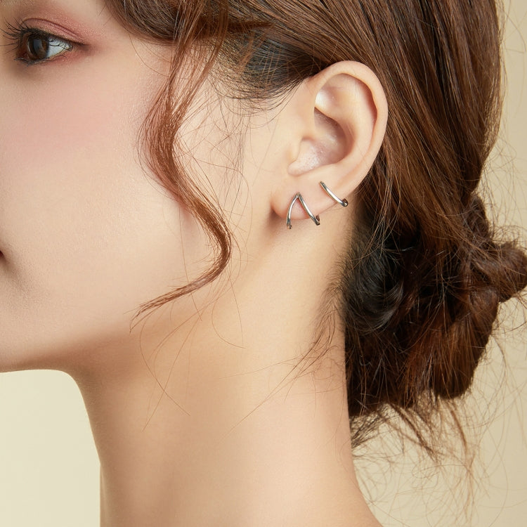 Sterling silver open line earrings on ear, curved angular U hoop style