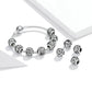 Silver-tone charm bracelet with elastic cord and carved letter bead charms in round settings