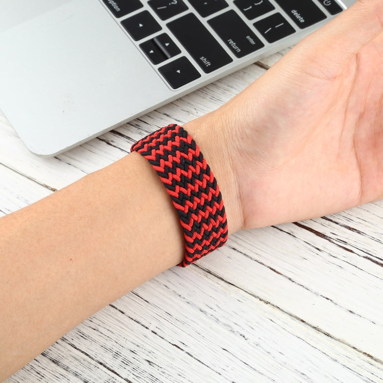 Red and black zigzag braided nylon watchband worn on a wrist