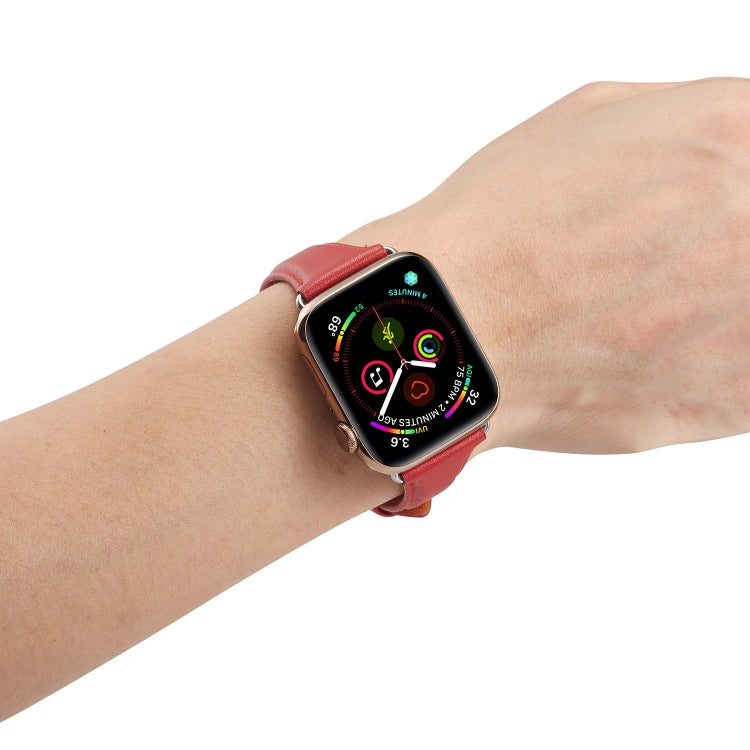 Genuine leather watch band in red on a wrist, metal buckle and pin holes