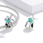 Silver windmill charm bead in teal enamel with pink CZ, shown with chain