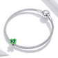 Silver mesh chain bracelet with green enamel clover charm bead at side