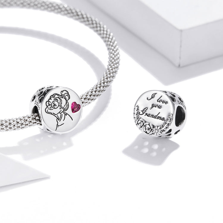 Two engraved silver charm beads with pink heart stones on a silver chain bracelet