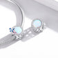 Sterling silver charm beads on bracelet chain, each with opal-like center and butterfly enamel