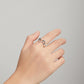 Sterling silver open wave ring with CZ accents on a hand