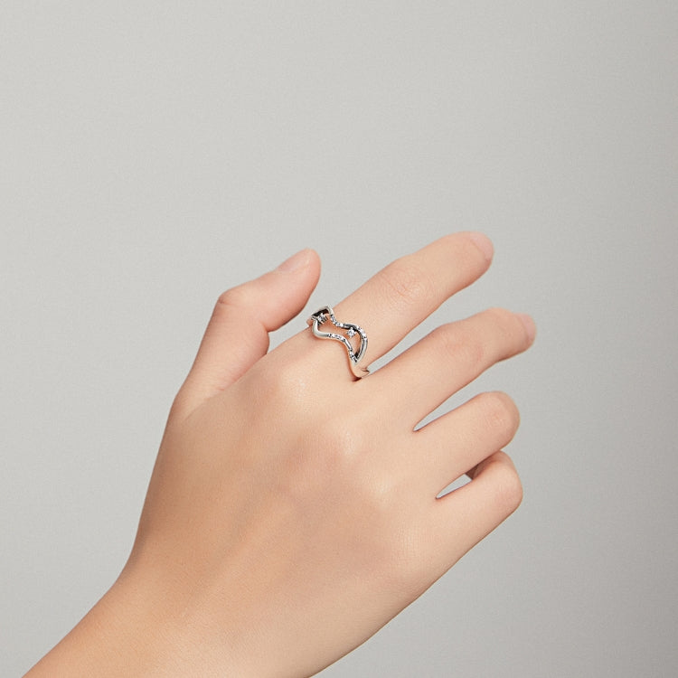 Sterling silver open wave ring with CZ accents on a hand