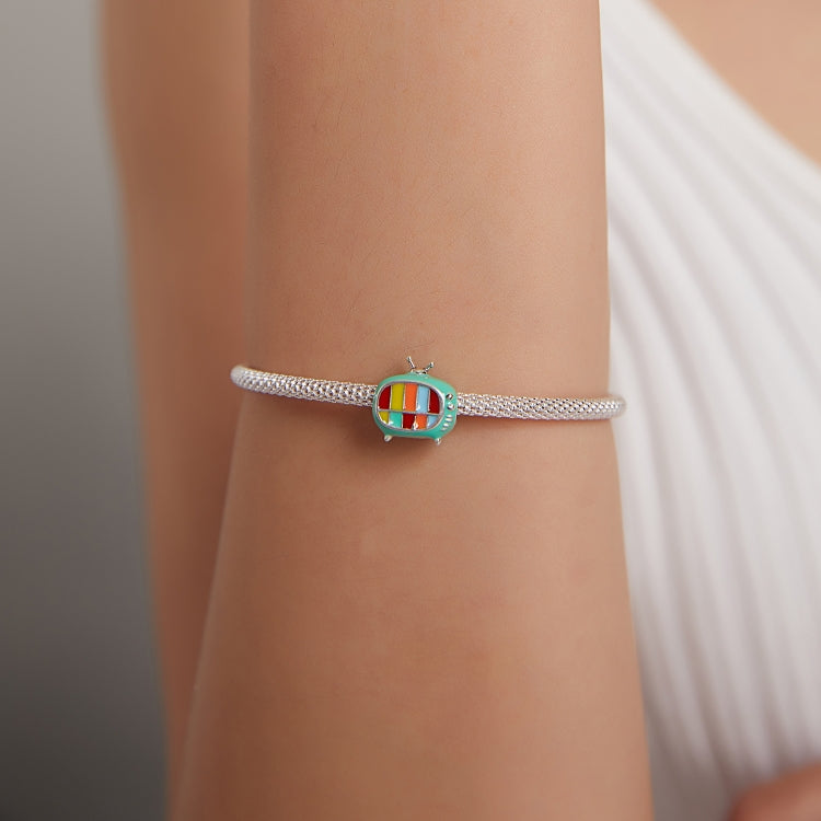 Wrist-worn silver bracelet featuring a green TV enamel charm bead